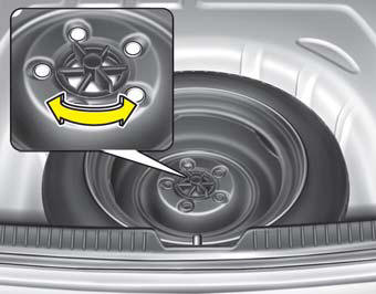 Turn the tire hold-down wing bolt counterclockwise.