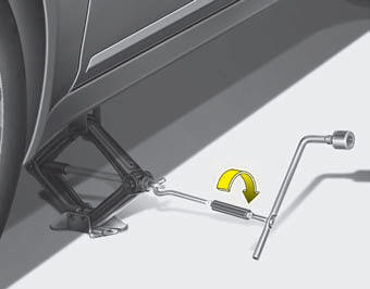 8. Insert the jack handle into the jack and turn it clockwise, raising the vehicle